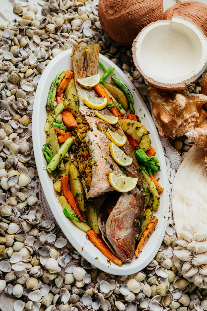 Peixe inteiro servido com legumes e limão